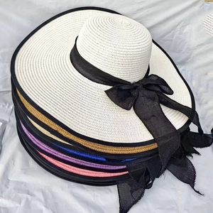 Foldable wide brim straw sun hat for women featuring a large black mesh bow decoration
