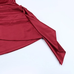 Detail of the asymmetrical pleated hemline on this shiny wine red satin mini dress