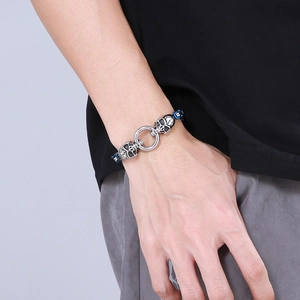 Men's retro stainless steel skull bracelet with blue and black woven band on wrist