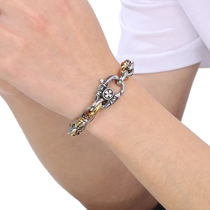 Dettaglio del bracciale in acciaio al titanio bicolore con motivo a croce e chiusura