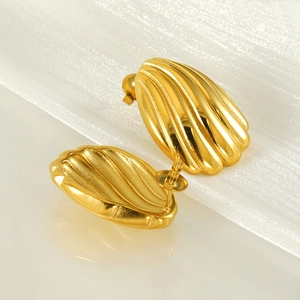 Macro shot of 18k gold plated stainless steel shell earrings with ribbed texture details
