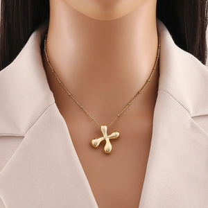 Dettaglio della collana con ciondolo a croce placcata oro 18K su una modella