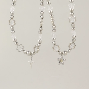 Detail of Y2K beaded necklaces with silver metal stars, flower pendants and clear beads