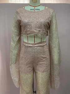 Detail shot of shimmering rose gold sequin crop top and high-waisted trousers set