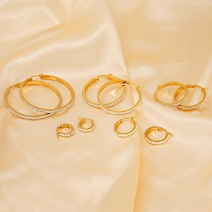 Detailed view of four pairs of 18k gold plated stainless steel hoops with inlaid crystals
