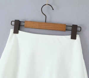 Détail de la texture satinée blanche et des motifs jacquard sur la mini-jupe
