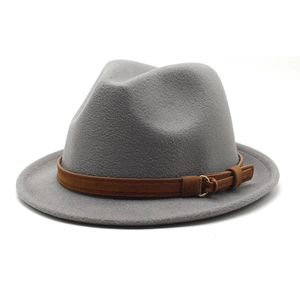 Detalle de sombrero fedora de lana gris con banda de cuero marrón y hebilla dorada
