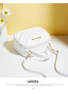 Detail view of white V-quilted small square crossbody bag with gold hardware and top handle
