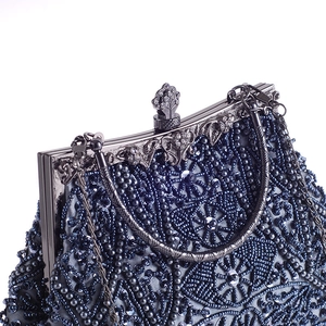 Dettaglio del ricamo di perline blu scuro con chiusura floreale in metallo decorato