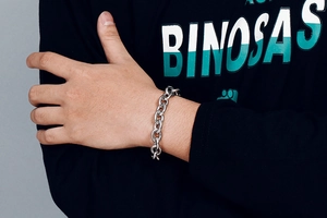 Detail of chunky silver stainless steel hollow link chain bracelet on model wrist