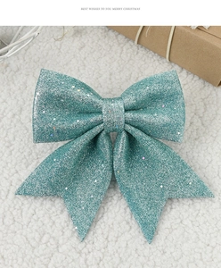 Detail of a sparkling turquoise sequined Christmas bow on a white plush holiday background