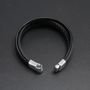 Detail of multi-layer black braided leather bracelet with silver magnetic metal clasp