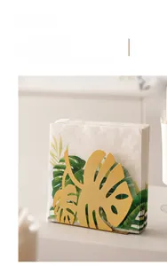 Detail of Nordic golden leaf napkin holder with creative metal art design for dining table