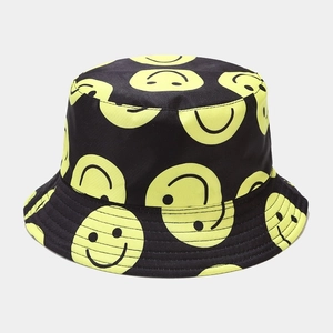 Detailed view of black bucket hat with yellow smiley face patterns and sturdy stitching
