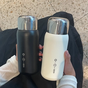 Detail of matte black and white insulated stainless steel bottles with silver metal caps