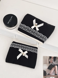 Detail shot of black lace cosmetic bags with satin bows and pearl charms set