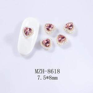 Détail de charmes à ongles cœur en cristal rose avec bordure de petites perles blanches