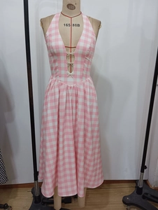 Detail von rosa kariertem Halter-Midikleid mit V-Ausschnitt und weißen Perlen-Schleifen
