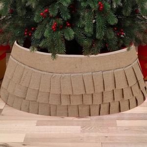 Rustic burlap Christmas tree skirt with pleated ruffles and white trim on wood floor