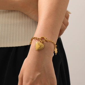 Vintage gold plated heart and flower pendant stainless steel bracelet worn on wrist