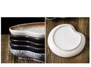 Detail of heart-shaped ceramic dish showing non-slip unglazed bottom on a dark wood table