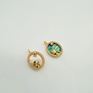 Macro shot of 18k gold-plated cat and star pendants with shell inlay and zircon border