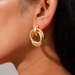 Close-up of elegant triple interlocking gold rings on ear with polished finish