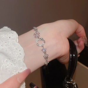 Close-up of Hello Kitty zircon bracelet with pink flower and star details on wrist