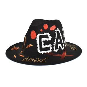 Detailed close-up of graffiti art design on black wool fedora with gold and white letters