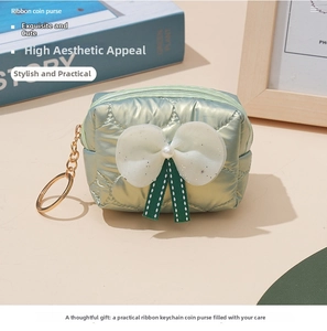 Detailed view of mint green quilted coin purse with white lace bow and pearl accent