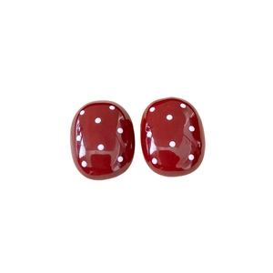 Fashionable red polka dot oval stud earrings in a minimalist retro style on white background