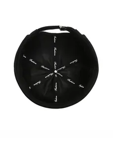 Detailed interior of black brimless cap with embroidered tapes and metal top buckle