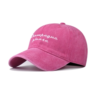 Close-up of rose red washed cotton cap featuring white Champagne please embroidery