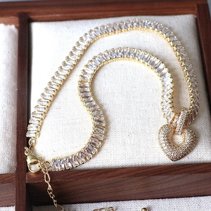 Elegant gold heart pendant necklace featuring sparkling rectangular cubic zirconia stones