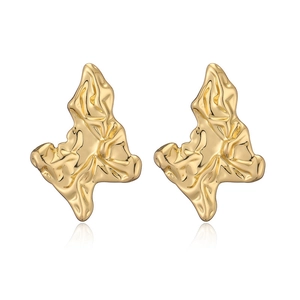Macro detail of 18K gold plated earrings with artistic lava texture and polished finish