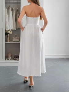 Detail of the white strapless dress featuring an open back and invisible zipper closure