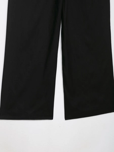 Detail shot showing the wide leg hem and textured fabric of these black trousers