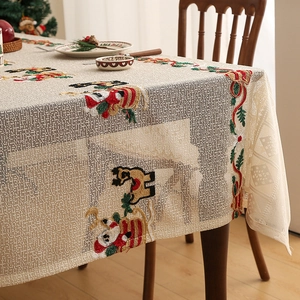 Detail of Christmas table runner with red embroidery and reindeer lace on a wooden table