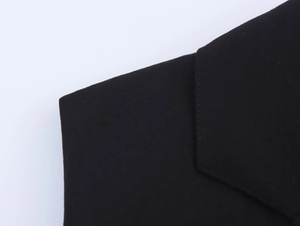 Détail rapproché des coutures et du tissu noir en mélange de lin sur le haut