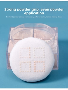 Detail of round plush powder puff showing excellent powder pickup on blue background