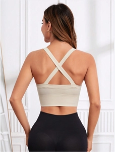 Détail des bretelles croisées du soutien-gorge de sport beige pour le yoga et le fitness