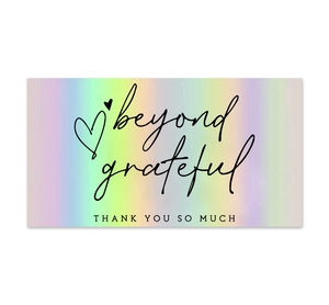 Macro shot of holographic rainbow Thank You card with beyond grateful text on white background