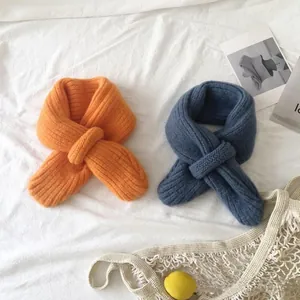 Close-up of soft knitted baby scarves in orange and blue with ribbed texture details