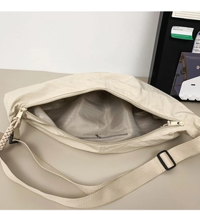 Vue intérieure du sac bandoulière en nylon blanc cassé avec compartiment principal et poche zip