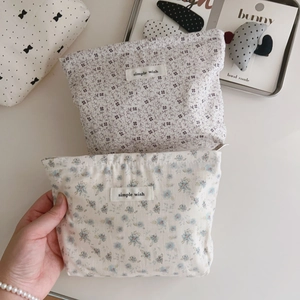 Detailed close-up of light gray floral cotton makeup pouches with Simple Wish woven labels