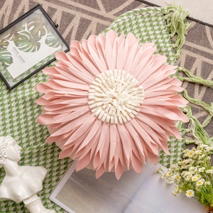 Detail of pink flower shaped decorative pillow made of soft fabric on a cozy rug