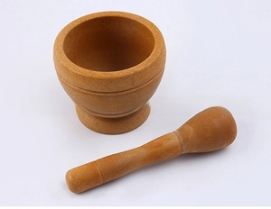 Detail view of wooden mortar and pestle set with natural grain and decorative grooves