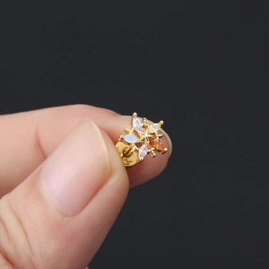 Détail macro d'un clou d'oreille étoile en or 18 carats serti de zircons multicolores