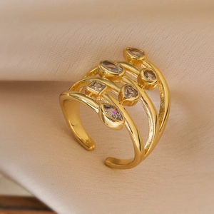 Macro shot of gold-plated multi-layer hollow ring with sparkling geometric zircons on silk