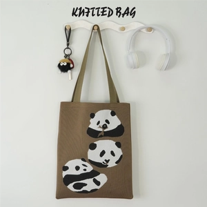 Close-up of brown knitted tote bag featuring three pandas eating bamboo patterns